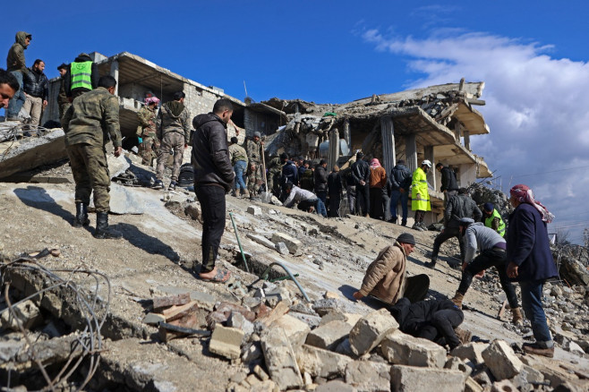 ruine și oameni încercând să îndepărteze dărâmături în Siria