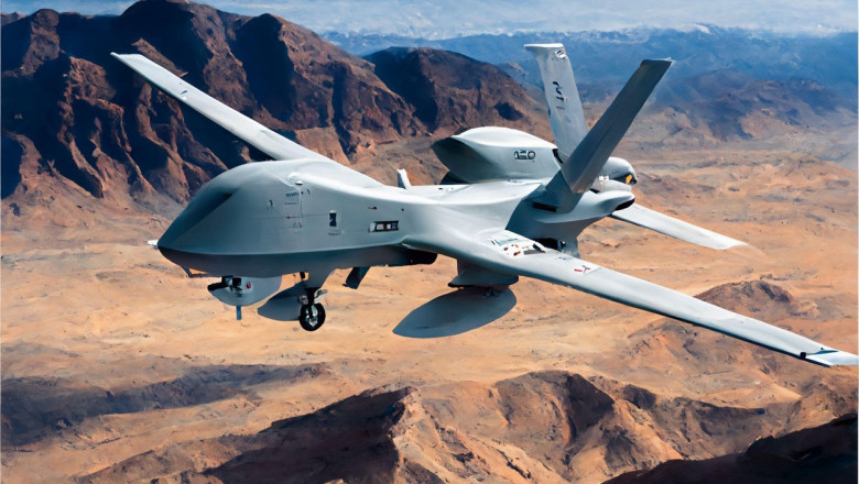 O dronă militară zboară deasupra unui teren deșertic.