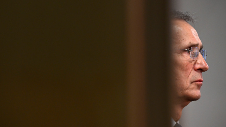 chipul lui Jens Stoltenberg, văzut prin crăpătura unei uși