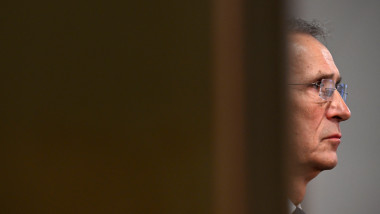chipul lui Jens Stoltenberg, văzut prin crăpătura unei uși