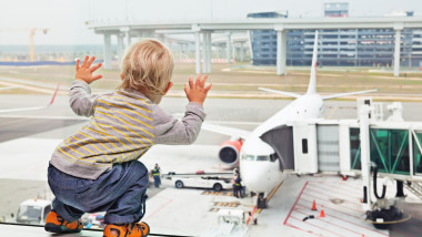 copil uitându-se la un avion de pe pista