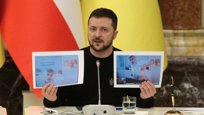Volodimir Zelenski ține în mâini două poze cu Mihail Saakașvili din închisoare