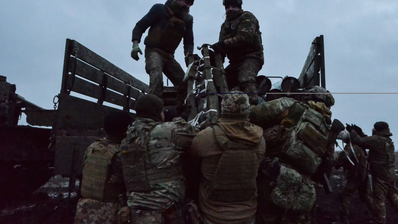 militari ucraineni descarca munitie de artilerie