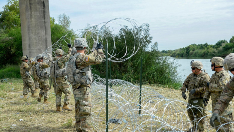 soldați americani pun sârmă ghimpată de-a lungul graniței dintre SUA și Mexic