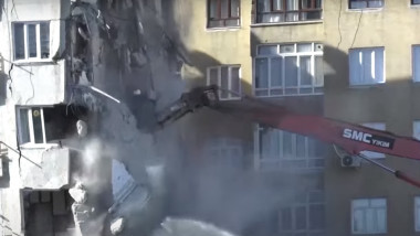 utilaj care demolează o cladire grav afariata de cutremurele din turcia