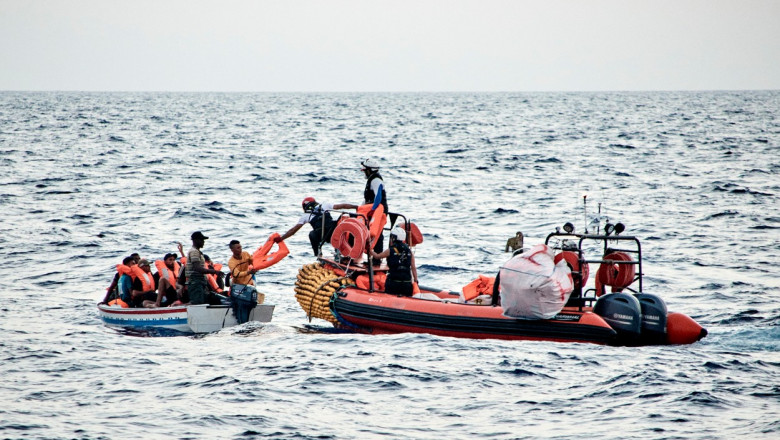 Membrii organizaţiei SOS Mediterranee împart veste de salvare celor 14 migranţi aflaţi în pericol pe o barcă, în Marea Mediterană, pe 1 iulie 2021.