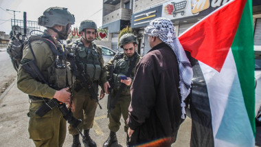 Un cetăţean palestinian discută cu mai mulţi soldaţi israelieni în timpul unui protest din Cisiordania pe 2 martie 2023.