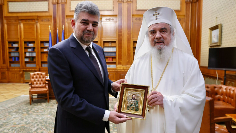Președintele Camerei Deputaților, Marcel Ciolacu și Patriarhul Daniel țin o icoană în mâini.