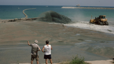 Lucrări de înnisipare a plajei din zona cartierului Faleza Nord pe16 august 2014.