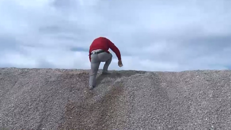 un om urca pe o duna de nisip de pe plaja din mamaia