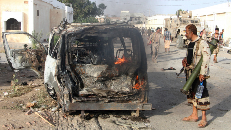 A Yemeni man looks at a burning vehicle following a reported suicide car bombing in Huta, the capital of the southern province of Lahj, a bastion of Al-Qaeda jihadists