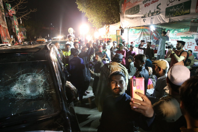 Imran Khan supporters wait outside his house after non-bailable arrest warrant issued