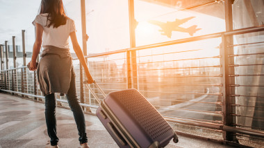 femeie cu bagajul in aeroport turista