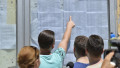Mai mulți elevi verifica rezultatele afișate pe un panou ale examenului de bacalaureat în Craiova, pe 12 iulie 2016.