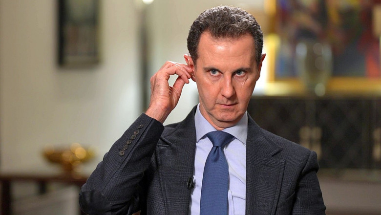 Assad își fixează o cască în ureche în timpul unui interviu în Rusia