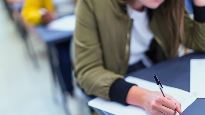 High school girl student taking exam at desk