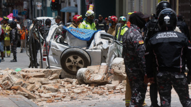 mașină distrusă de un zid prăbușit după cutremur