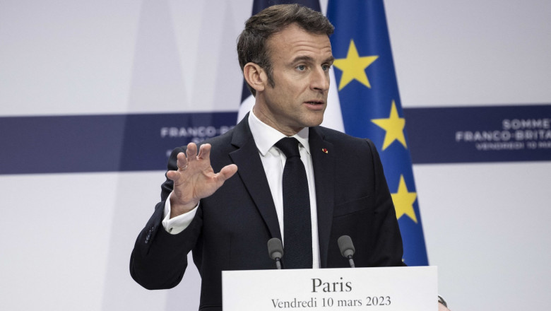 Președintele francez Emmanuel Macron gesticuleaza cu mana in impul unei conferinte