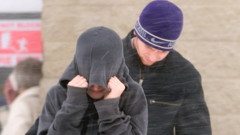 Couple sheltering from the blowing snow and wind chill during a winter storm