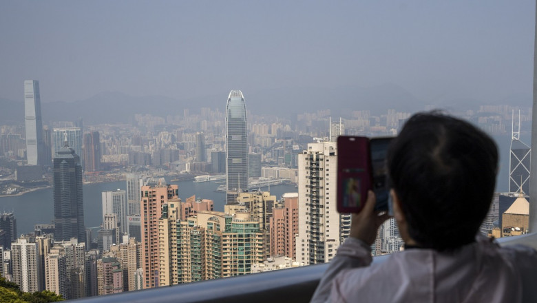 o femeie face o fotografie cladirilor din hong kong