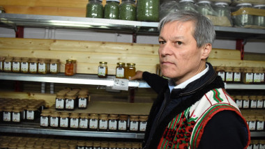 Dacian Cioloș in costum popular, in camara cu borcane pe rafturi
