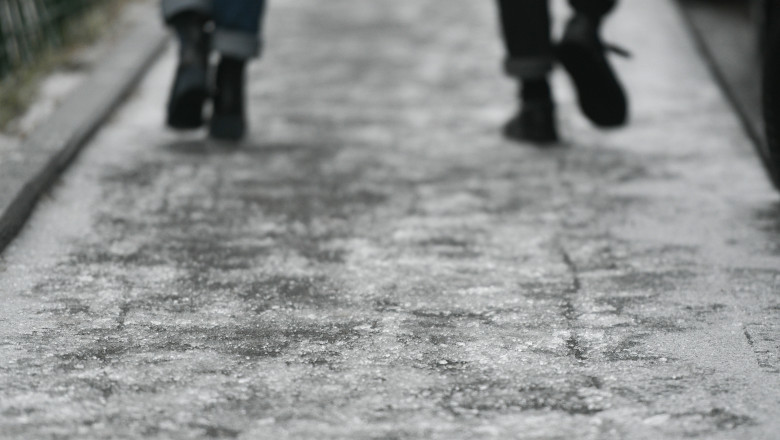 Două persoane merg pe un trotuar înghețat din București pe 25 ianuarie 2019..