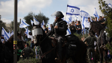 Jandarm călare și protestatari cu steaguri ale Israelului