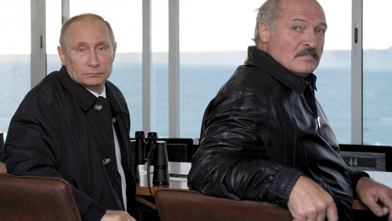 Vladimir Putin și Aleksandr Lukașenko în geacă de piele, se uită peste umăr