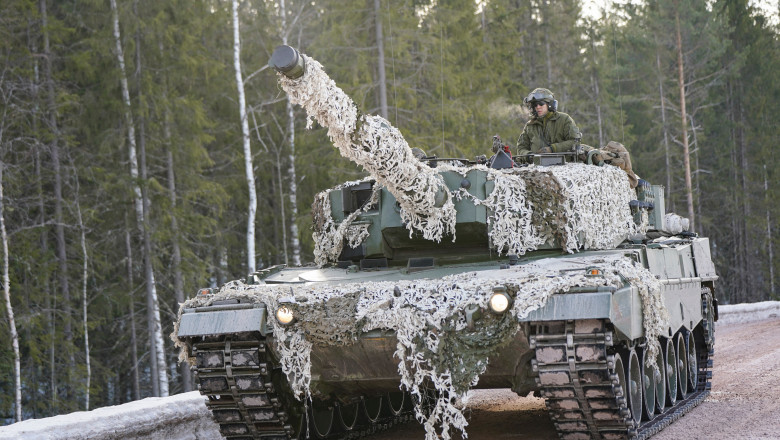 tanc Leopard 2 din dotarea armatei norvegiene, cu camuflaj de iarnă, se deplasează pe un drum înzăpezit