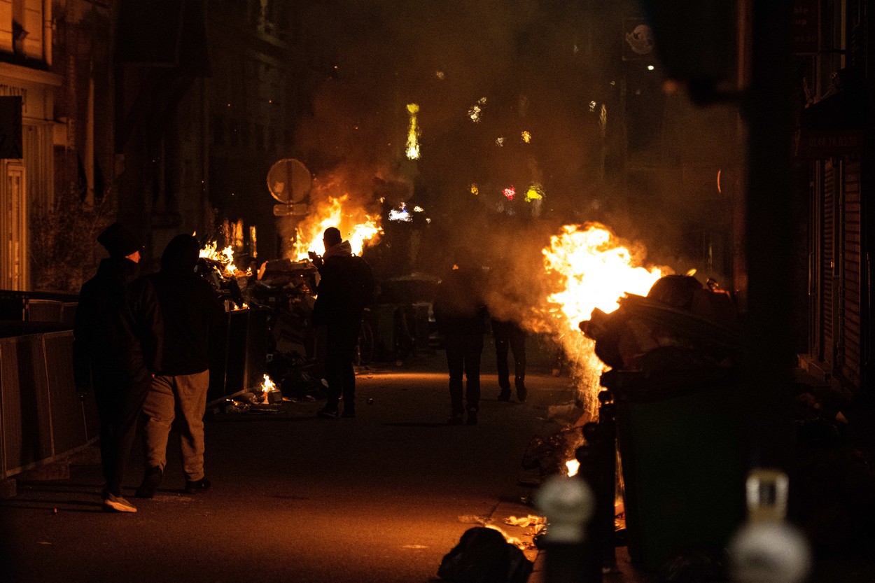 Peste 100 de protestatari au fost reținuți la Paris. Oamenii au incendiat pubele după ce guvernul a supraviețuit moțiunilor de cenzură
