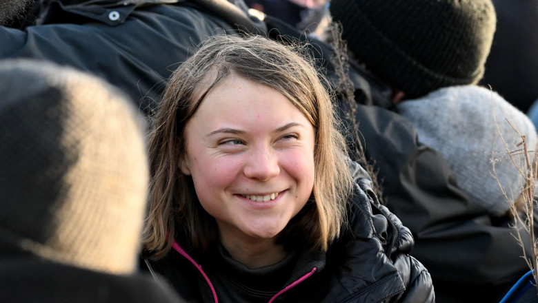 Erkelenz, Germany. 17 January 2023, North Rhine-Westphalia, Erkelenz: Police officers have encircled a group of activists and coal opponents with climate activist Greta Thunberg (M) on the edge of the Garzweiler II opencast lignite mine during a protest a