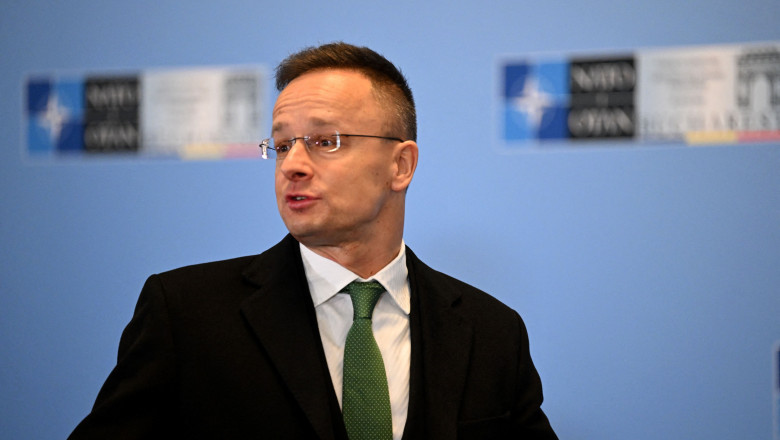 ministrul ungar de Externe, Peter Szijjarto, mirat, între două afișe NATO