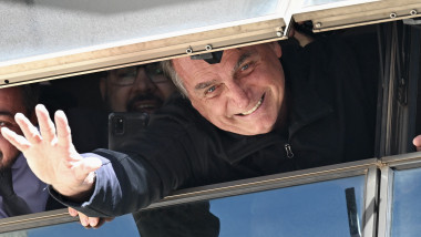 Jair Bolsonaro face cu mâna de sub un geam