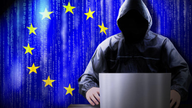 Anonymous hooded hacker, flag of European Union, binary code - cyber attack concept