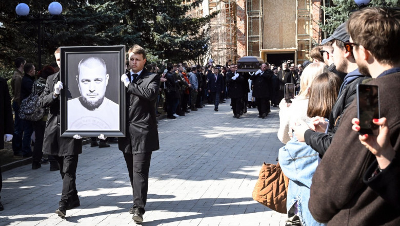 doi oameni poarta un portret al lui tatarski in spate se vede sicriiul