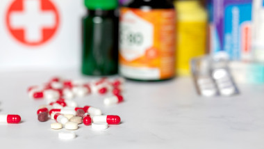 medicamente și recipiente cu medicamente pe o suprafață albă