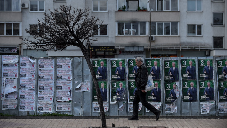 man walks past an elections campaign posters of Revival party leader Kostadin Kostadinov in Sofia, Bulgaria