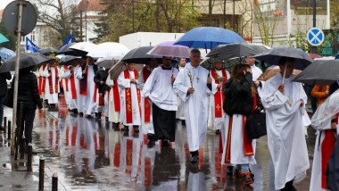 preoti catolici cu umbrele, procesiune de florii pe strada