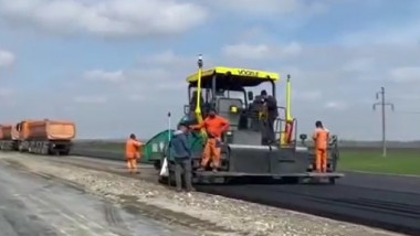Muncitori toarnă asfalt pe drumul expres Galați-Brăila pe 3 aprilie 2023.