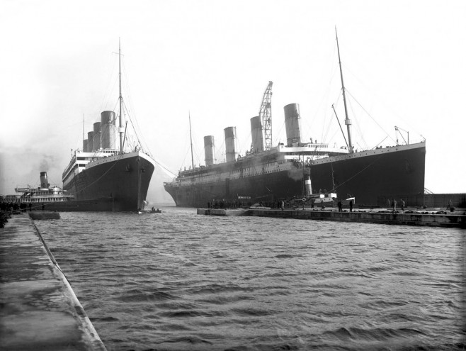 UK: RMS Titanic (right) moving out of the drydock to allow her sister liner, RMS Olympic, to replace a damaged propeller blade, Belfast, 6 March 1912