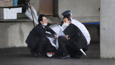 A man (bottom) is arrested after throwing what appeared to be a smoke bomb in Wakayama on April 15, 2023, in timpul discursului lui kishida