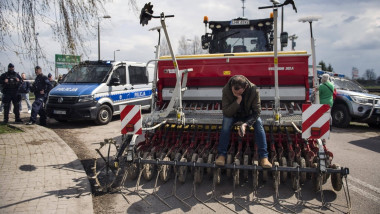 A protesting farmer seats on his harvester during the protest at the broad-gauge railway line crossing in Hrubieszow border town