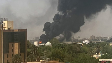 O coloană de fum iese dintr-o clădire avariată în timpul luptelor din capitala Sudanului, pe 16 aprilie 2023.