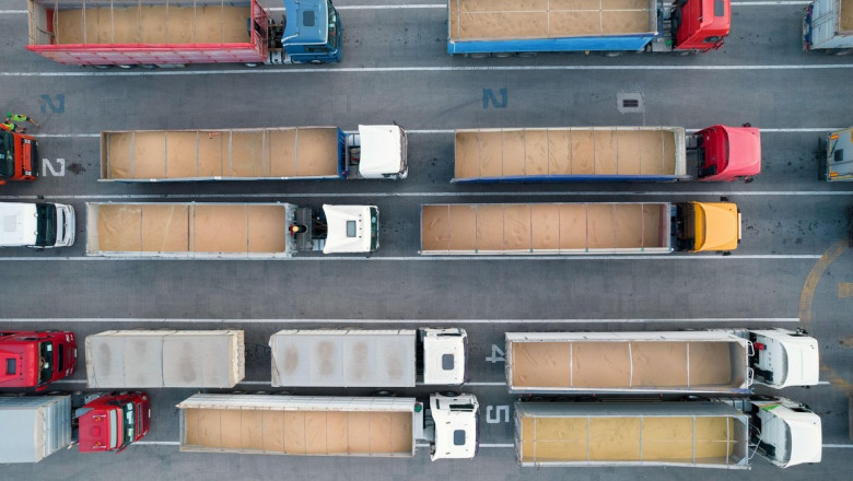 Many trucks are waiting in line for unloading in the port harbor, top view from a quadcopter on trucks loaded with grain. Concept for logistics and fr