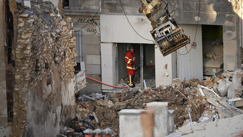 Un pompier caută supraviețuitori pe 10 aprilie 2023 sub dărâmăturile unei clădiri din Marsilia care s-a prăbușit în urma unei explozii pe 8 aprilie 2023.