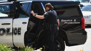 Un ofițer de poliție din SUA deschide portiera unei mașini de poliție pe 13 iunie 2021.