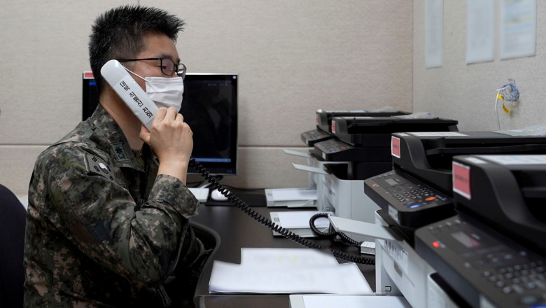 un militar coreean cu mască cu un receptor inscripționat cu un text în limba coreeană