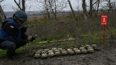 militar ucrainean lângă un șir de mine antipersonal și antitanc pe un câmp de lângă Izium, Ucraina