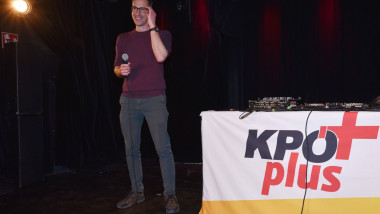 principalul candidat al comuniștilor, Kay-Michael Dankl, vorbeste la microfon langa un banner cu kpoplus