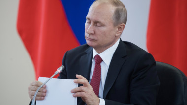 Vladimir Putin ține în mână un document